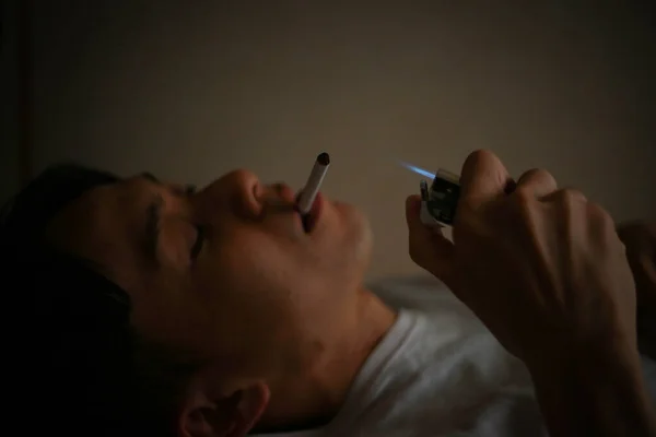 Férfi Dohányzik Cigaretta Ágyban — Stock Fotó