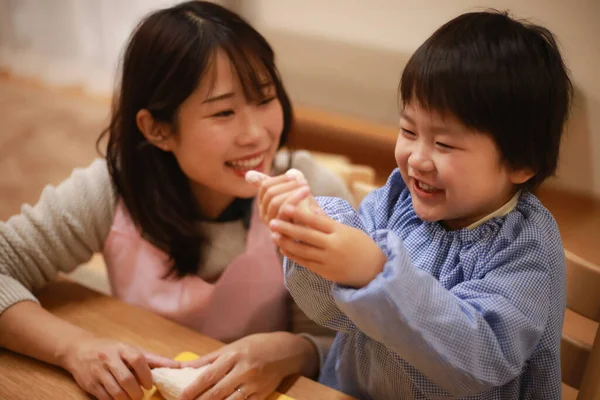 Küçük çocuk ve annesi mangırla oynuyorlar. 