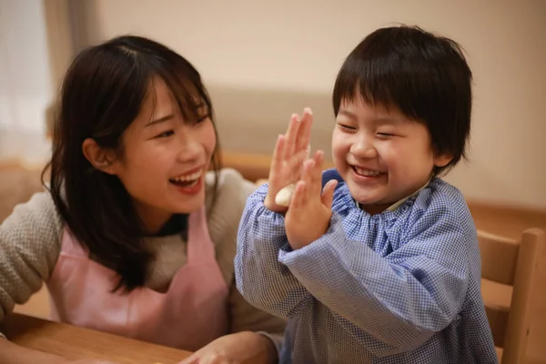 Küçük çocuk ve annesi mangırla oynuyorlar. 