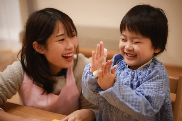 Küçük çocuk ve annesi mangırla oynuyorlar. 