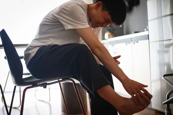 Asijský Muž Trpí Bolestí Nohou Doma — Stock fotografie