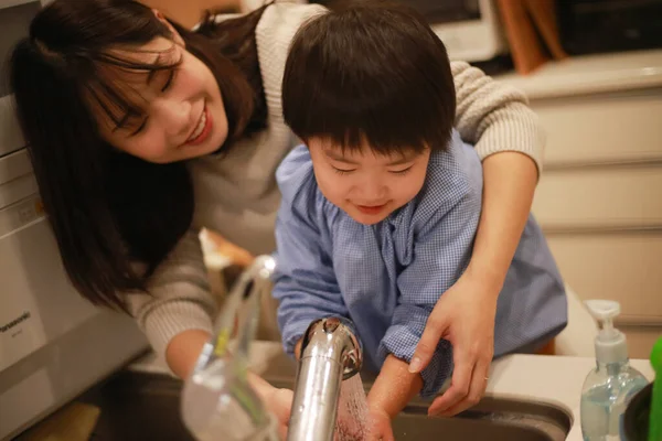 アジア系の若い女性と小さな息子が手を洗い — ストック写真
