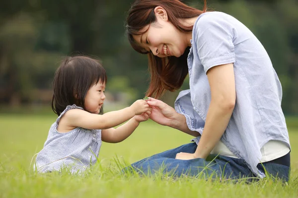 Anne ve kızı parkta oynuyorlar.