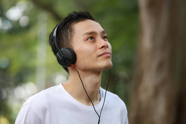 Asijský Muž Poslouchá Hudbu Parku — Stock fotografie