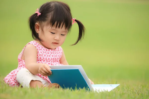 Schattig Klein Meisje Spelen Met Boek Het Park — Stockfoto