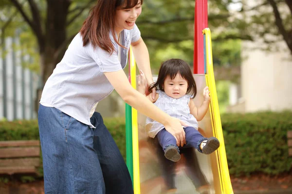 Anne ve kızı oyun alanında oynuyorlar.