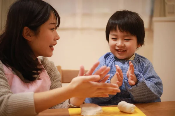 Küçük çocuk ve annesi mangırla oynuyorlar. 