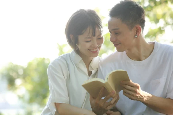 Asiático Pareja Lectura Libro Verde Prado — Foto de Stock