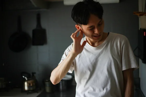 若い男が耳に触れ台所の騒音に苦しみ — ストック写真