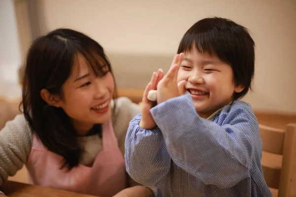 Küçük çocuk ve annesi mangırla oynuyorlar. 