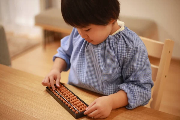 Küçük çocuk evde eğitim oyunu oynuyor.  