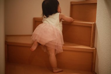 Merdivenleri tek başına çıkan bir kız resmi.