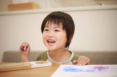 Asyalı küçük çocuk resim yapıyor.