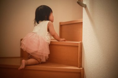 Merdivenleri tek başına çıkan bir kız resmi.