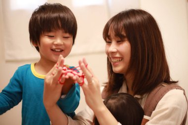 Asyalı anne ve oğul evde oynuyorlar.