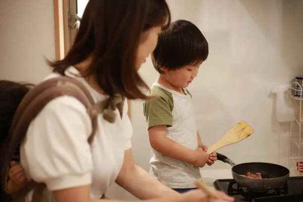 妈妈和孩子们在厨房里做饭 — 图库照片