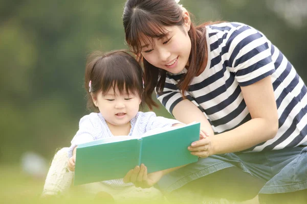 Szczęśliwa Matka Córka Siedzą Trawie Czytają Książkę — Zdjęcie stockowe