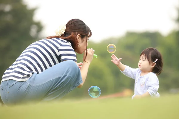 Ευτυχισμένη Μητέρα Και Κόρη Παίζουν Στο Γρασίδι Σαπουνόφουσκες — Φωτογραφία Αρχείου