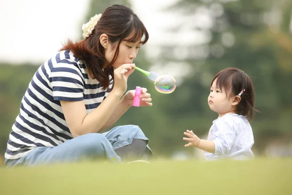 Lycklig Mor Och Dotter Leker Gräset Med Såpbubblor — Stockfoto