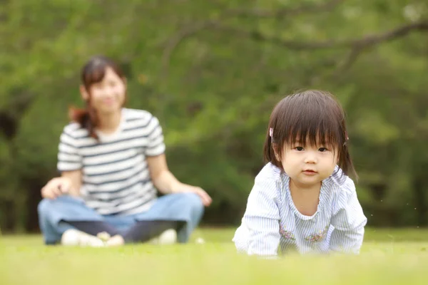 Mutter Sieht Kleine Tochter Auf Gras Kriechen Und Kamera Schauen — Stockfoto