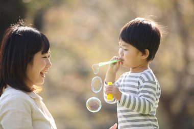 Asyalı anne çocuğuyla oynuyor.