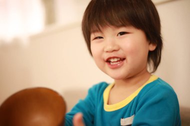 Kahverengi kase tutan küçük şirin bir çocuğun portresi.