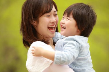 Genç Asyalı anne ve küçük oğlu parkta eğleniyorlar.  