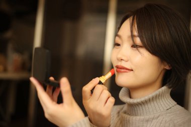 Makyaj yapan güzel bir kadının portresi.