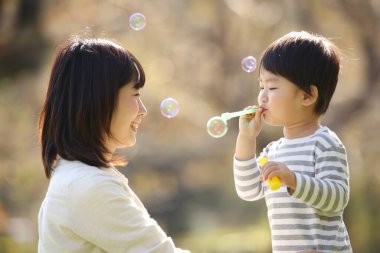 Asyalı anne çocuğuyla oynuyor.