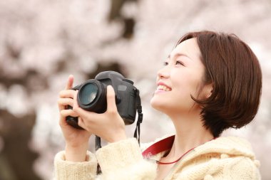 Parkta kamerası olan genç bir kadın.