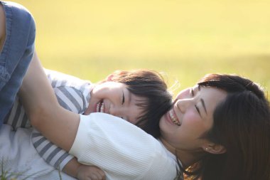 Asyalı anne çocuğuyla oynuyor.