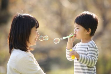 Asyalı anne çocuğuyla oynuyor.