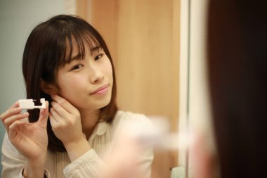 Asyalı genç bir kadının portresi. Kulak delici.