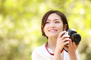 Parkta kamerası olan genç Asyalı kadın. 