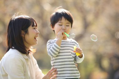 Asyalı anne çocuğuyla oynuyor.