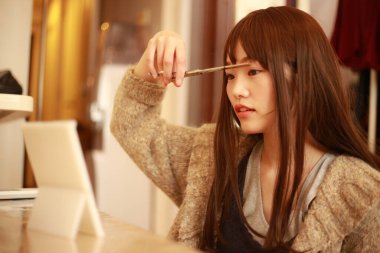 Güzel Asyalı kadın saçını kesiyor. 