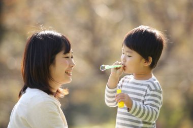 Asyalı anne çocuğuyla oynuyor.