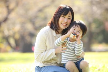 Asyalı anne oğluna sarılıyor.