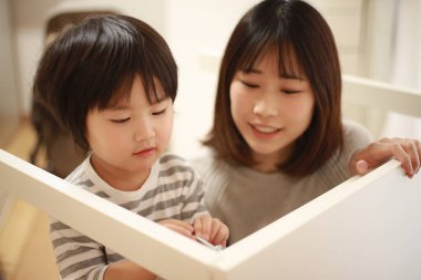 Küçük oğlu olan Asyalı kadın yeni evinde toplanıyor.