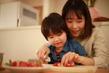 Anne oğluyla yemek pişiriyor. Çocuk mutfağı.