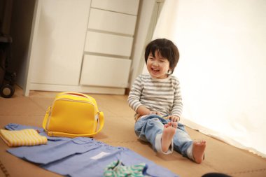 Sevimli küçük çocuk evde pantolon giyiyor.