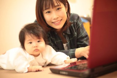 Kadın çocuğuyla birlikte evden çalışıyor.