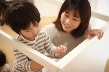 Küçük oğlu olan Asyalı kadın yeni evinde toplanıyor.