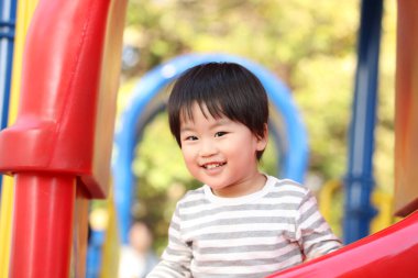 Oyun parkında oynayan sevimli erkek bebek.