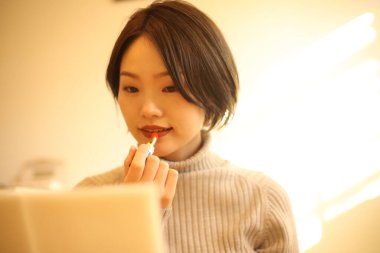 Makyaj yapan güzel bir kadının portresi.