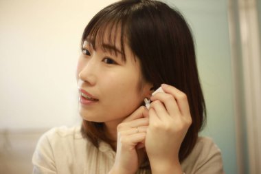 Asyalı genç bir kadının portresi. Kulak delici.