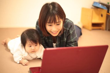 Kadın çocuğuyla birlikte evden çalışıyor.