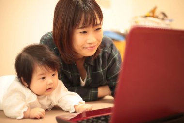 Kadın çocuğuyla birlikte evden çalışıyor.