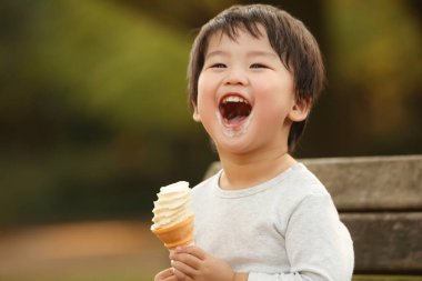 Dışarıda dondurması olan sevimli çocuk.