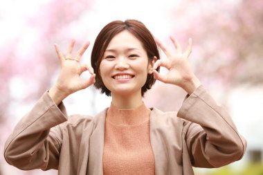 Genç Asyalı kadın parkta iyi görünüyor. 